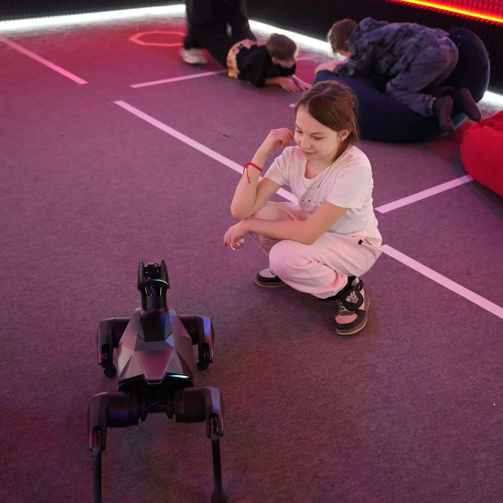 Девочка присела рядом с роботом-собакой Xiaomi CyberDog 2 на празднике