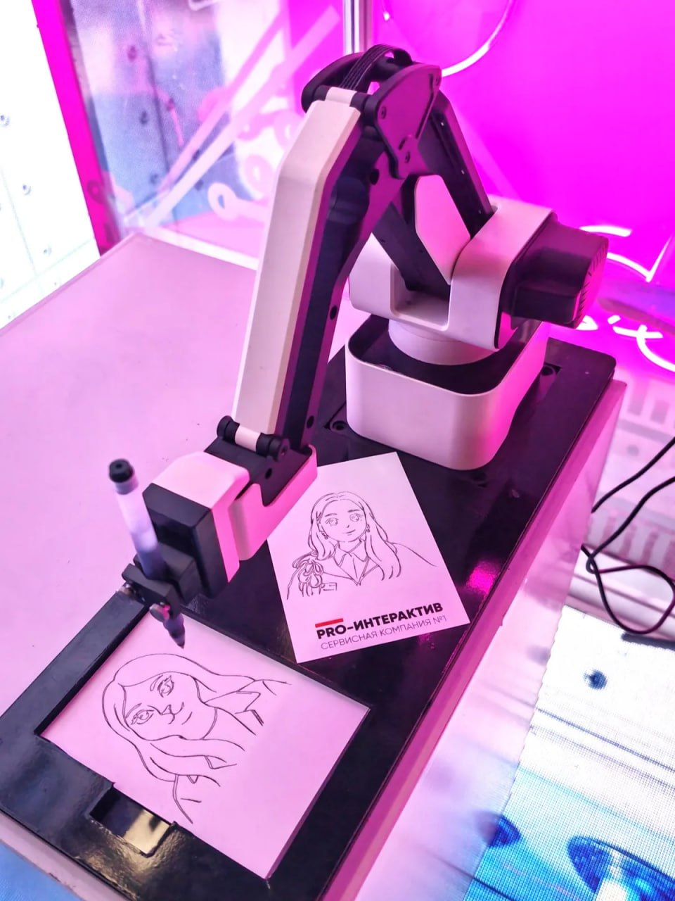 Робот-художник Sketchbot рисует портрет гостя на стенде выставки