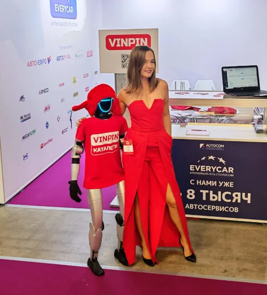 Unitree G1 в красной шапке рядом с представительницей стенда