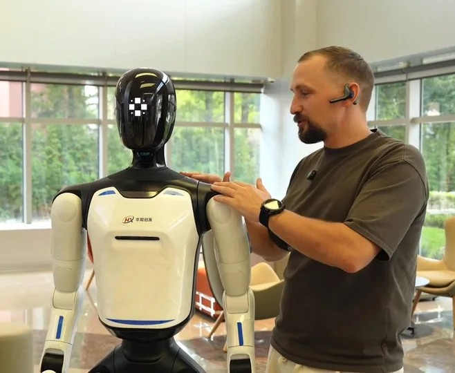 Человек касается плеча робота Agibot A3 Ultra с датчиками касания